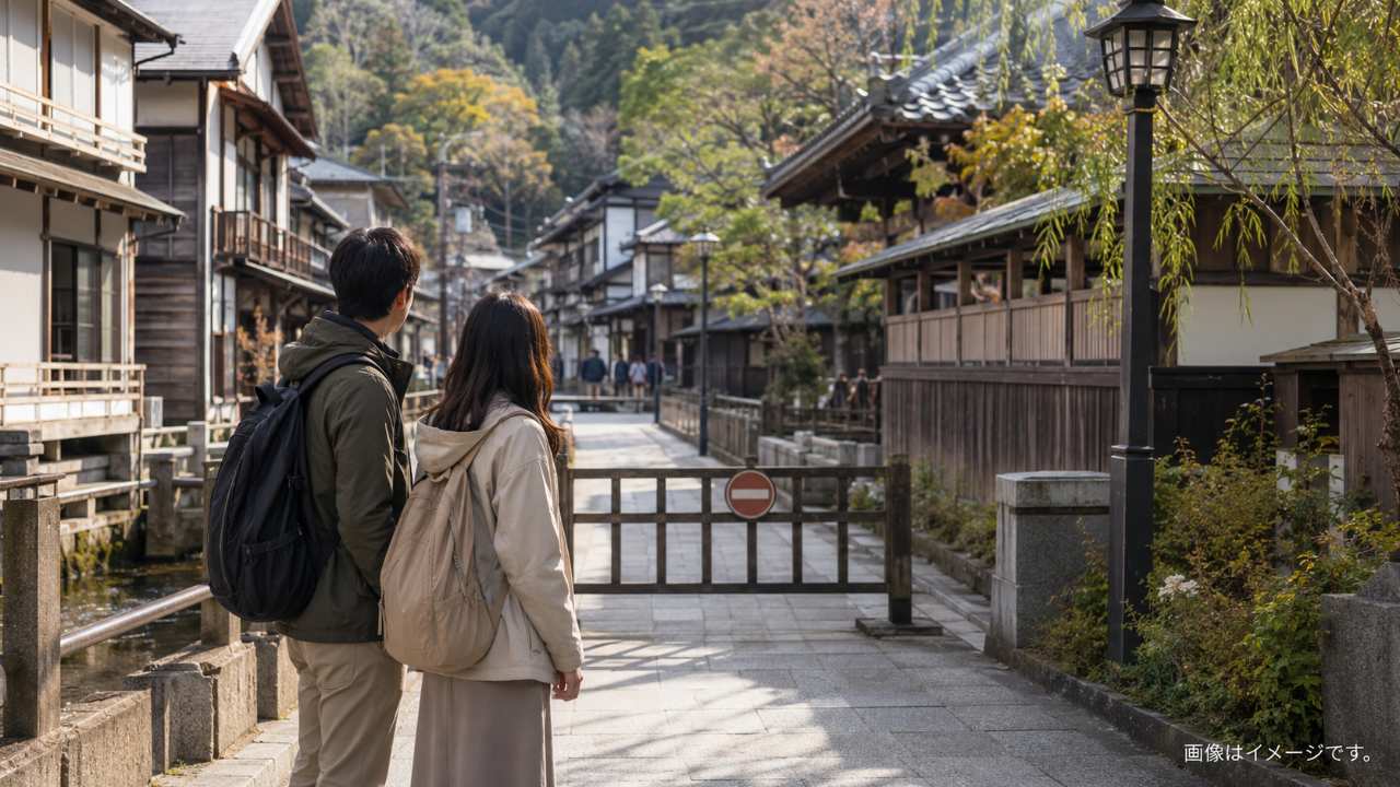 旅行者が立入禁止の表示を見て引き返し、歩道から静かな町並みを眺めている場面